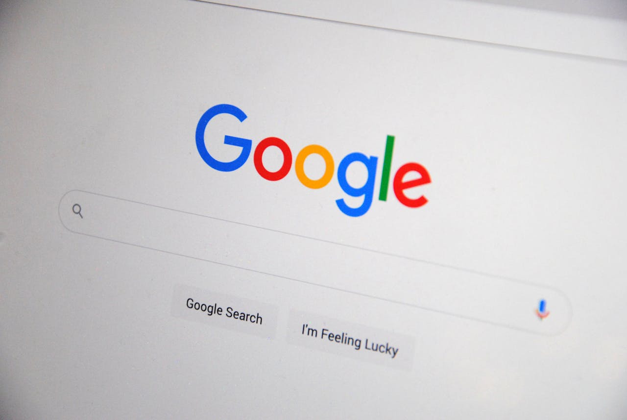 about-01 Close-up of the Google homepage on a screen showing search options.